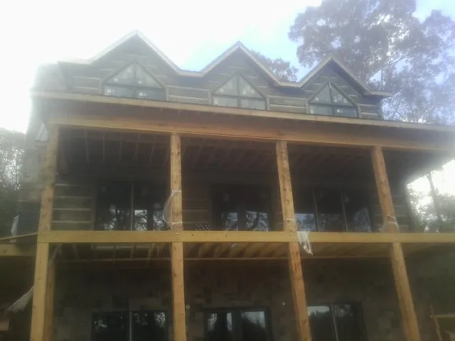 Dormers and porch framing on a large log home under construction — Roof Coating work by our crew in Trappe