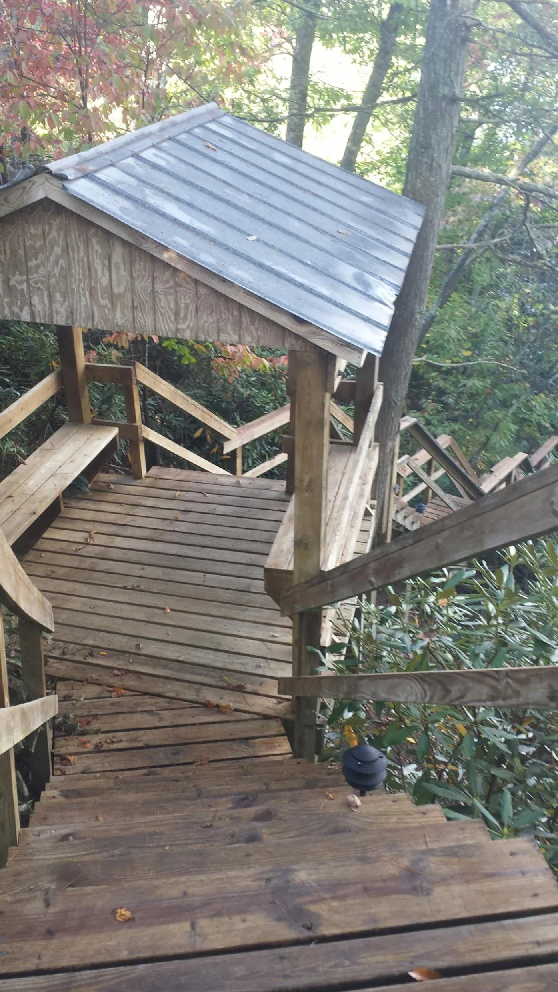 Metal roofed shelter over wooden steps on a wooded walkway — Skylight Repair & Installation work by our crew in Trappe