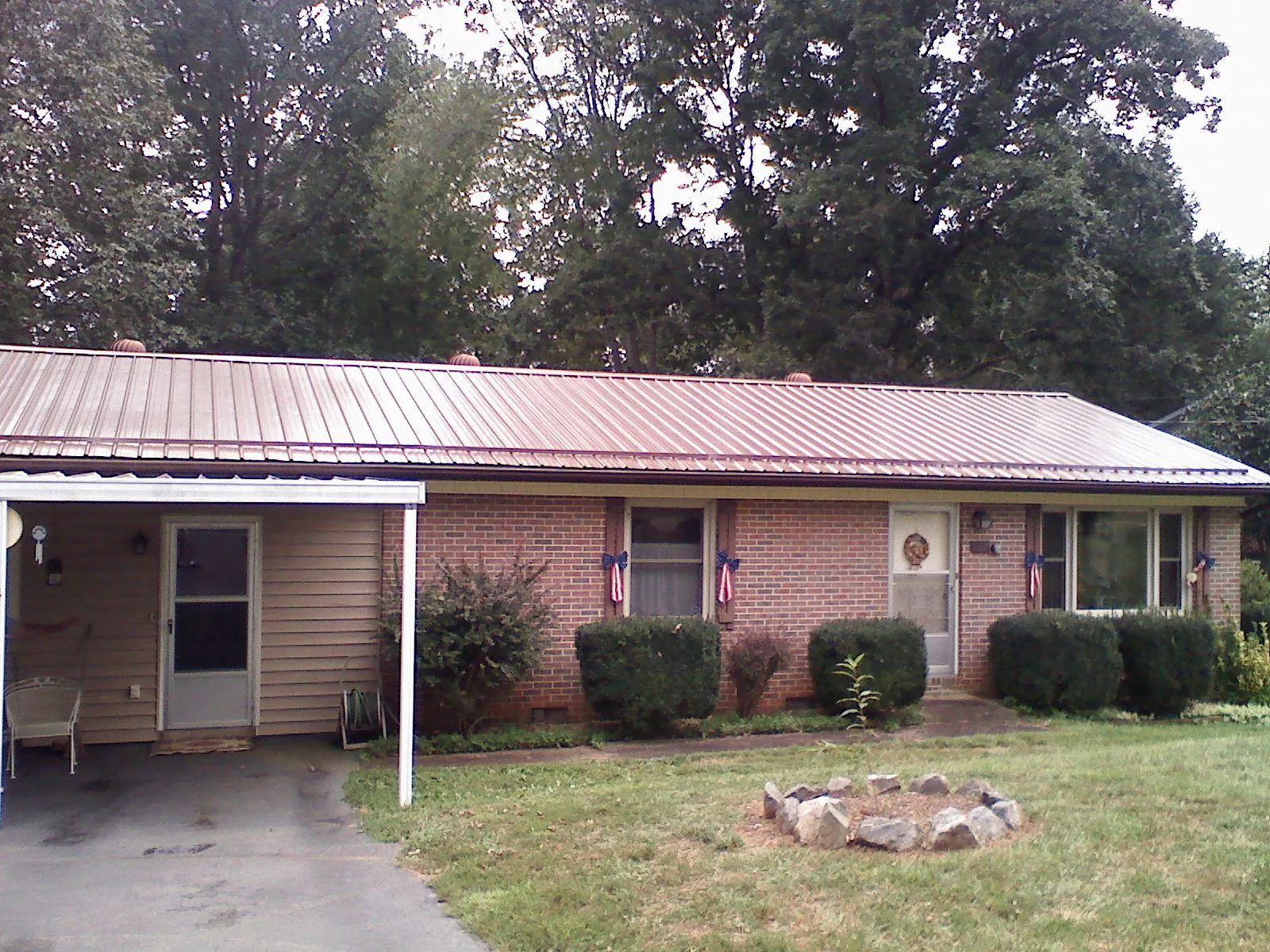 Bronze metal roof and carport on a brick ranch home — Roof Repair work by our crew in Trappe